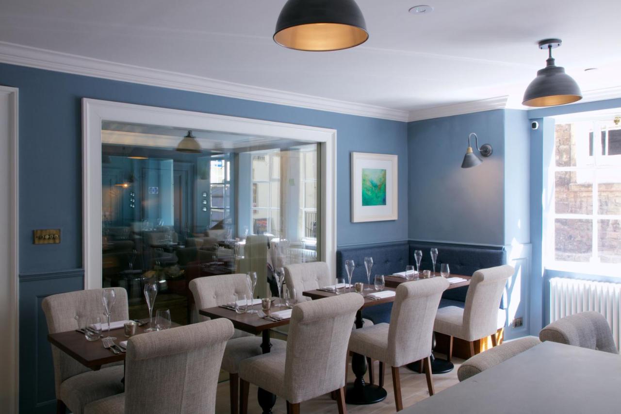 a dining room with tables and chairs and a window at Eight in Bath