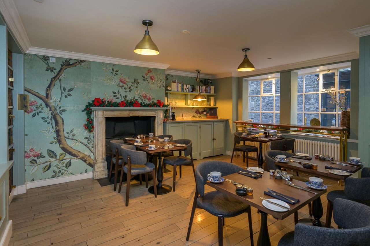 a restaurant with tables and chairs and a fireplace at Eight in Bath